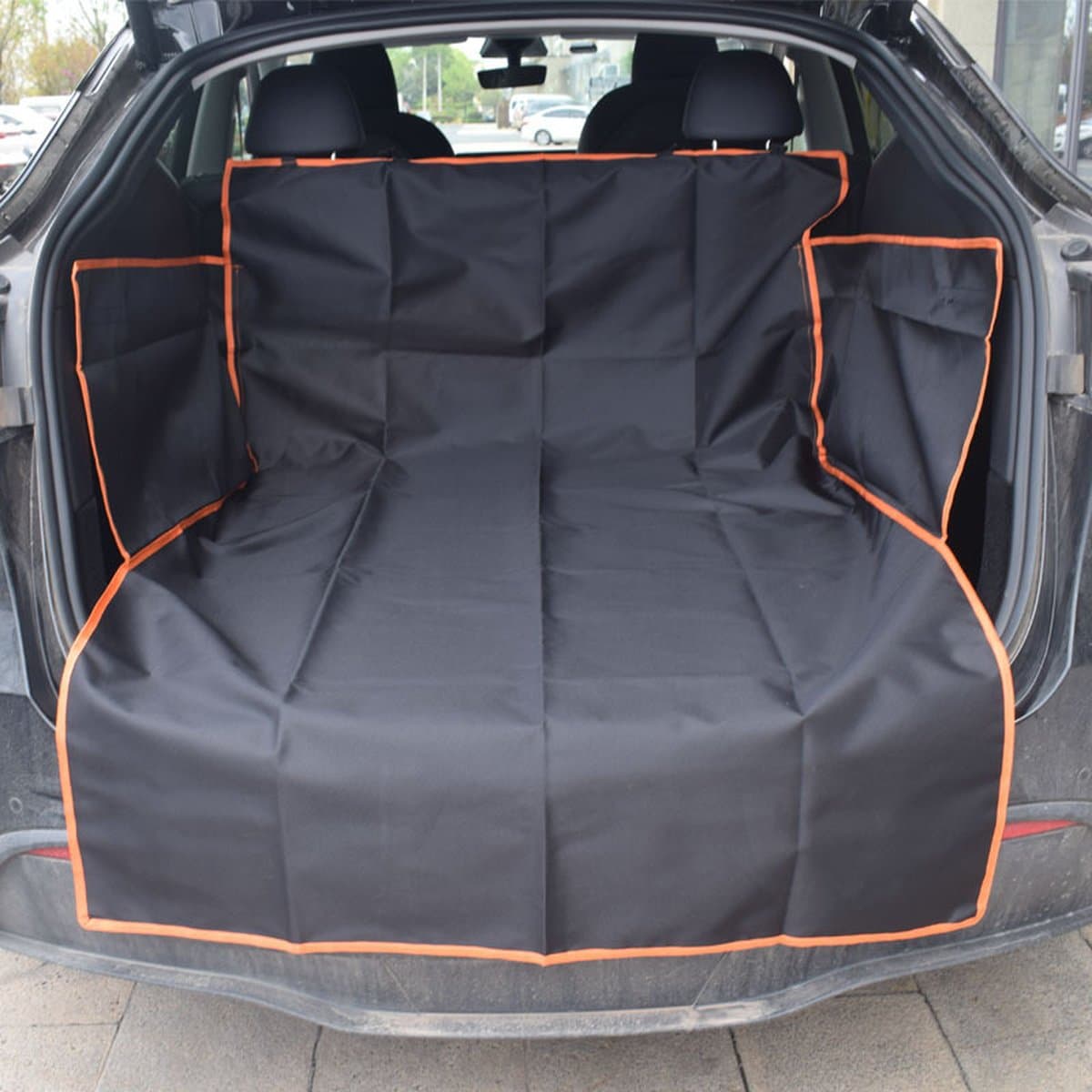 Black cargo liner with orange edge fitted in an SUV, covering the floor, side walls and bumper